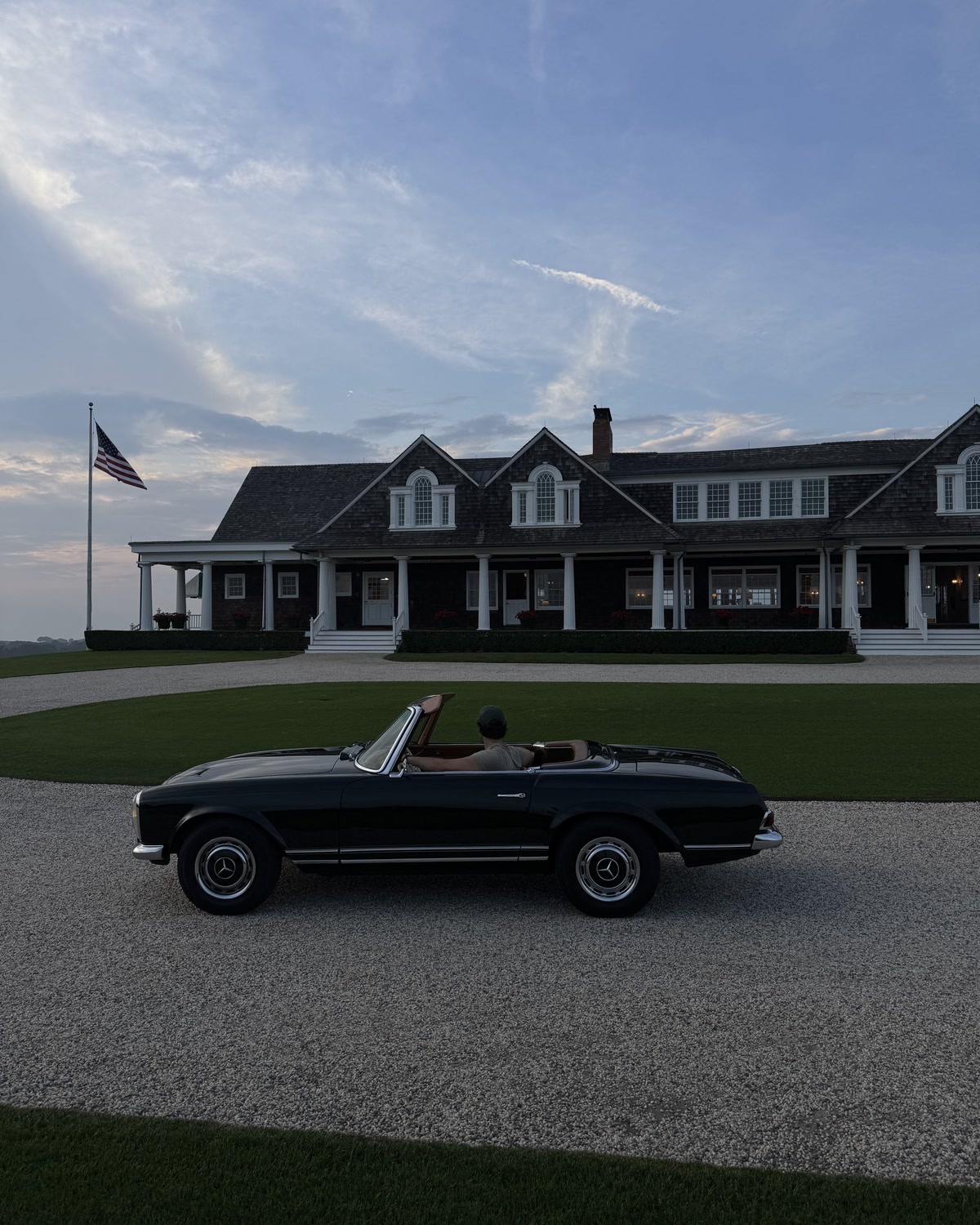 Dark Mercedes-Benz Pagoda outside a coastal home
